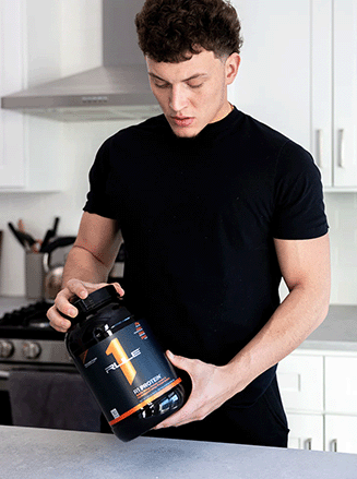 Picture of male holding R1 Protein in the kitchen