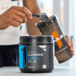 Image of person adding glutamine to their shaker in the kitchen